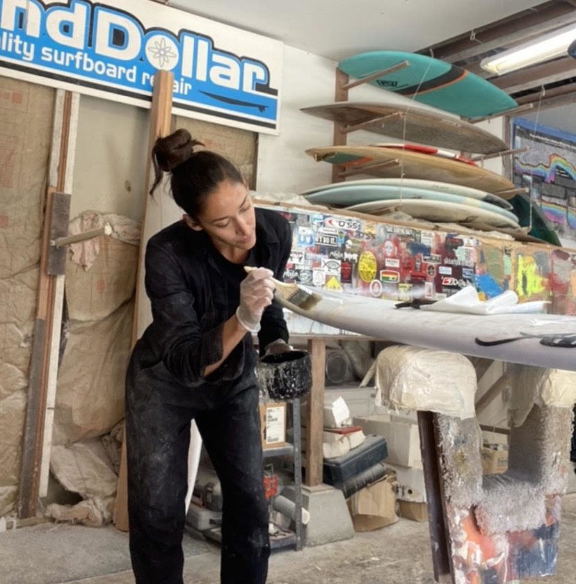 Brittney Barrios of Santa Cruz working on some surfboard ding repair for Sand Dollar